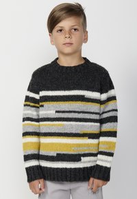Debel pleten pulover v temno sivi barvi, ki ima vodoravne črte v beli, črni, rumeni in sivi barvi. Okrugli izrez in rebrasti manšeti.