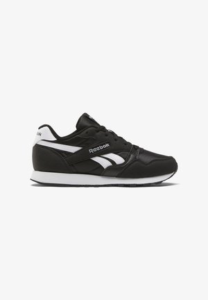 Black athletic sneaker with white accents, featuring a textured upper, lace-up design, cushioned sole, and Reebok branding on the side.