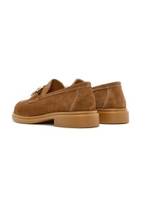 Braune Wildleder-Loafers mit runder Zehenpartie und niedrigem Gummihighheel. Verfügt über ein gestepptes Design und einen dekorativen Hardware-Akzent an der Vorderseite.