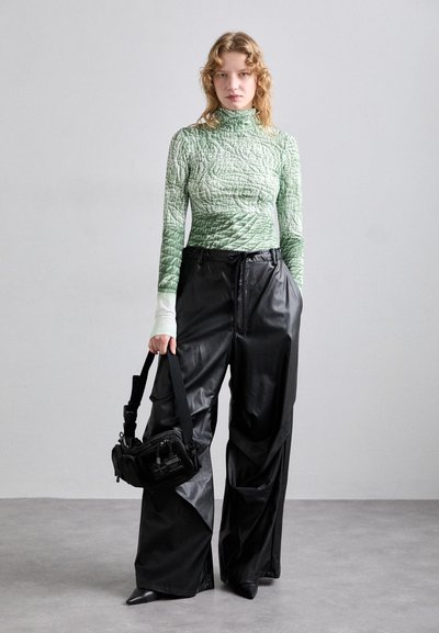 Quilted green long-sleeve top with textured pattern; black, loose-fitting leather pants; small black bag with strap; pointed black shoes.
