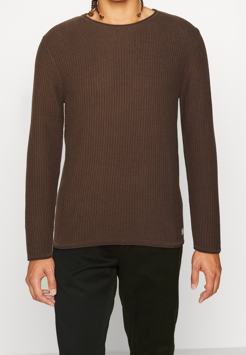 Pull brun à manches longues en maille avec un motif texturé, col rond et bordure contrastante aux poignets et à l'ourlet.