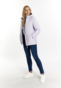 Ljuslila vadderad jacka med huva, dragkedja och två sidofickor. Bärs över en svart topp och kombineras med blå jeans och vita sneakers.