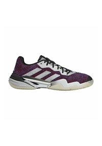 Scarpa sportiva testurizzata rossa e viola con strisce bianche, dettagli neri, colletto imbottito e rinforzo sul tallone argentato. Suola in gomma con scanalature per il grip.