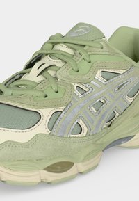 Lysegrønn og kremfarget løpesko med reflekterende sølvstriper, nettingstoff, semskede detaljer og tykk polstret såle.