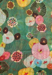 Colorful floral fabric featuring large, circular blooms in pink, yellow, black, and green on a turquoise background with fine linear details.
