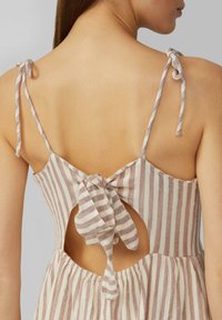 Gestreiftes Kleid in Hellbraun und Creme mit einer Bindeschließe im Rücken, ausgestattet mit einem Ausschnitt und dünnen, verstellbaren Trägern.