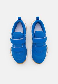 Baskets de sport bleues avec des bandes Velcro, tige en maille, col rembourré et semelle en caoutchouc blanche. Présente des surpiqûres blanches contrastantes.