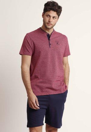 Polo shirt rojo jaspeado con cuello azul marino, mangas cortas y tapeta de tres botones. Presenta un pequeño logotipo azul en el pecho.