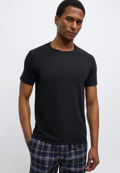 Μαύρο κοντομάνικο μπλουζάκι με στρογγυλή λαιμόκοψη, κατασκευασμένο από απαλό ύφασμα. Συνδυάζεται με πιτζάμες με καρό σχέδιο σε μπλε και γκρι αποχρώσεις.