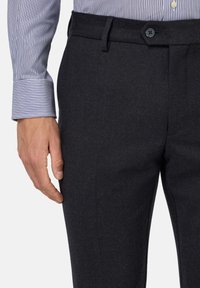 Temno sivi hlače z gladko teksturo, z gumbom in nabranim sprednjim delom, v kombinaciji z lahkim srajčnim rokavom s črtami.