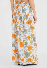 Jupe maxi florale blanche avec imprimé floral orange et vert. Taille élastique et design à volants avec une texture fluide.
