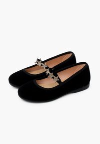 Schwarze Samt-Ballettschuhe mit einer runden Zehenform, die über eine dekorative, sternförmige Schnalle an der Vorderseite und eine glatte, flache Sohle verfügen.