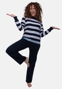 Randig långärmad skjorta i marinblått, vitt och ljusblått, kombinerad med marinblå avslappnade byxor. Mjuk tyg, avslappnad design och komfortabel passform.