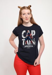 Námořnické tričko s grafickým potiskem Kapitána Ameriky, vystihující živé barvy, detailní design postavy a výrazný text "KAPITÁN AMERIKA."