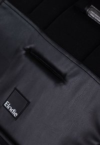 Svart läderväska med en mjuk textur, med en stikt paneldetalj och ett rektangulärt varumärkesmärke som står "Elodie".