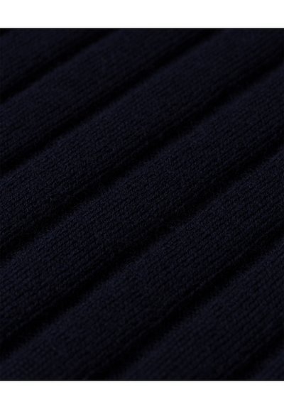 Mornarska pletenina s rebrastom teksturom, koja sadrži naizmjenične uzdignute i udubljene pruge, stvarajući ujednačen uzorak.