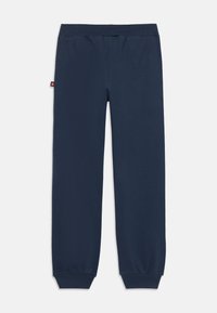 Marineblaue Sweatpants mit elastischem Bund, gerippten Knöchelbündchen und einem kleinen roten Logosticker an der linken Seitennaht.