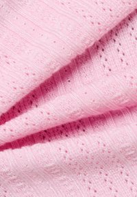 Tissu en tricot rose avec un motif texturé présentant des rayures horizontales et de petits trous. Matériau doux, léger et flexible.