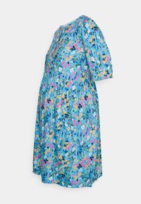 Vestido de maternidade floral com um fundo azul claro e flores rosas, laranjas e brancas. Mangas curtas e bufantes e um corte solto.