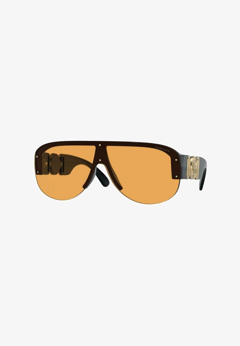 Occhiali da sole oversize marroni con lenti arancioni, dettagli in oro sulle tempie e punte nere. Design elegante e aerodinamico.