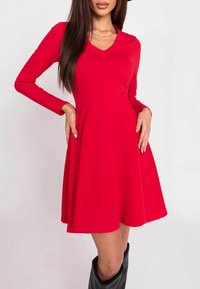 Rotes, langärmliges Kleid mit V-Ausschnitt, tailliertem Oberteil und ausgestellt Rock. Hergestellt aus glattem Stoff mit einem knielangen Saum.