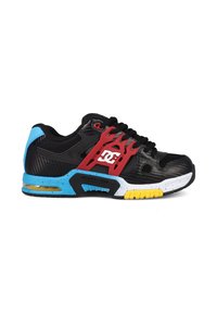 Baskets noires avec talon et semelle bleus, support latéral rouge avec logo DC blanc, lacets noirs et accents jaunes sur la semelle.