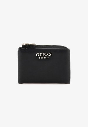 Portafoglio in pelle nera con chiusura a zip e un'incisione del logo argento "GUESS EST 1981" sulla parte anteriore. Texture liscia con accenti minimi.