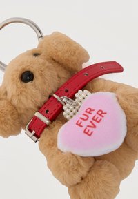 Porte-clés peluche ours en peluche avec yeux noirs, collier rouge et une étiquette en forme de cœur rose portant l'inscription "FUR EVER", attachée par des perles imitant des perles.