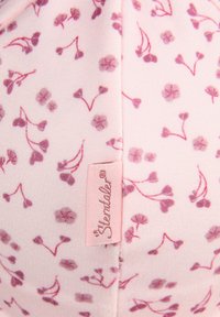Soft pink fabric with small purple floral patterns and a pink tag sewn in the center with cursive text.