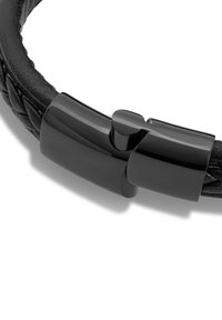 Schwarzes geflochtenes Lederarmband mit einem glänzenden schwarzen Metallverschluss. Glatte Textur mit einem modernen Design. Ovaler Schnitt, schlanker Erscheinungsbild.