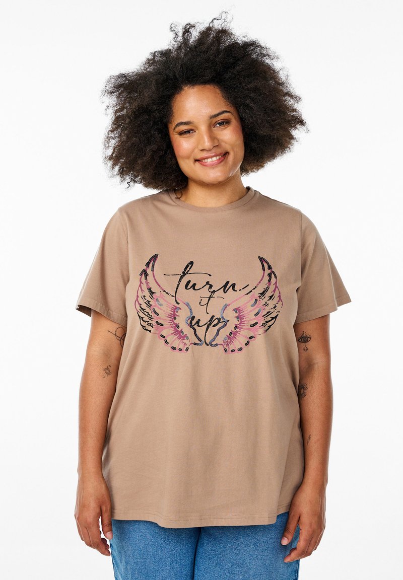 Braunes Baumwoll-T-Shirt mit lockerer Passform, ausgestattet mit einem grafischen Design von bunten Flügeln und dem Text "turn it up" in Schwarz.