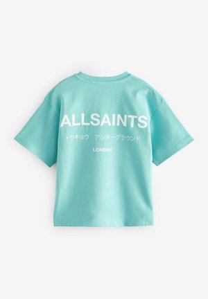 Ein hellblaues Baumwoll-T-Shirt mit kurzen Ärmeln, einem runden Ausschnitt und einem großen weißen Druck auf dem Rücken mit Text in Englisch und Japanisch.