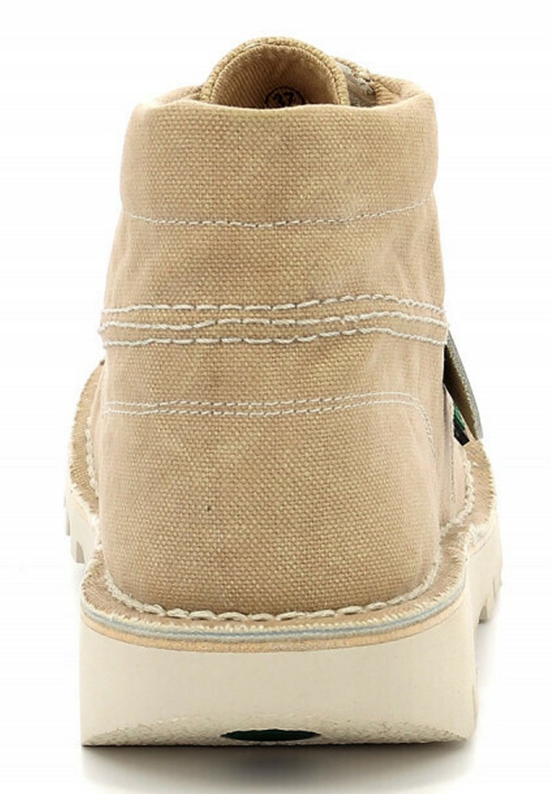 Botas de tobillo de lona beige con costuras blancas, puntera redonda y suela de goma blanca. Presenta una costura a lo largo del talón y detalles acentuados en los laterales.