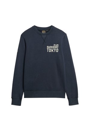Granatowa bluza crewneck z teksturowanym wykończeniem. Posiada haftowane logo "Tokyo" oraz akcent na rękawie. Żebrowany dekolt i mankiety.