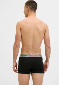 Schwarze Boxershorts mit einem grauen Bund, der roten Text "JACK & JONES" zeigt. Glattes Material und figurnahe Passform mit niedrigem Schnitt.