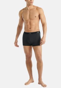 Svarta boxertrosor i stretchig tyg, med en slät midjeresår och diskret logotyp, åtsittande design och längd till mitten av låret.