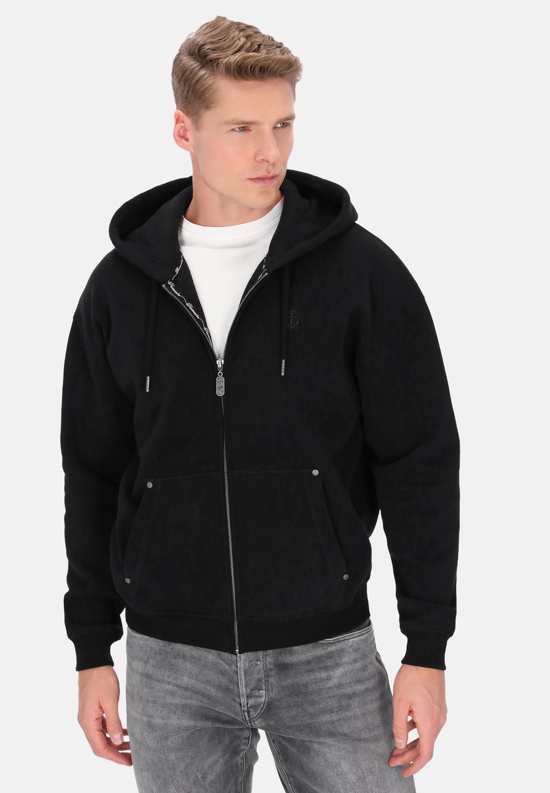 Zwarte zip-up hoodie met een gestructureerd donker patroon, verstelbare capuchon en twee voorzakken. Voorzien van zilverkleurig beslag en elastische manchetten.