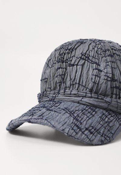 Gorra azul con una tela texturizada que presenta patrones de costura azul. El borde curvado y el diseño recogido acentúan su forma y estilo.
