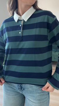 Grün und marineblau gestreiftes langärmliges Poloshirt mit einem weißen Kragen, das über Knöpfe am Ausschnitt verfügt und einen lässigen Schnitt hat.