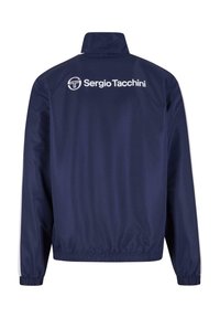 Námornícky modrá vetrovka s vysokým golierom, elastickými manžetami a bielym logom "Sergio Tacchini" potlačeným na chrbte. Hladký povrch.