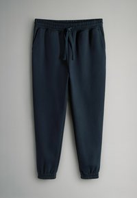 Jūras spēku sporta bikses ar elastīgu jostu un auklu, ar sānu kabatām un sašaurinātiem pēdējiem galiem, izgatavotas no mīksta, gluda auduma.