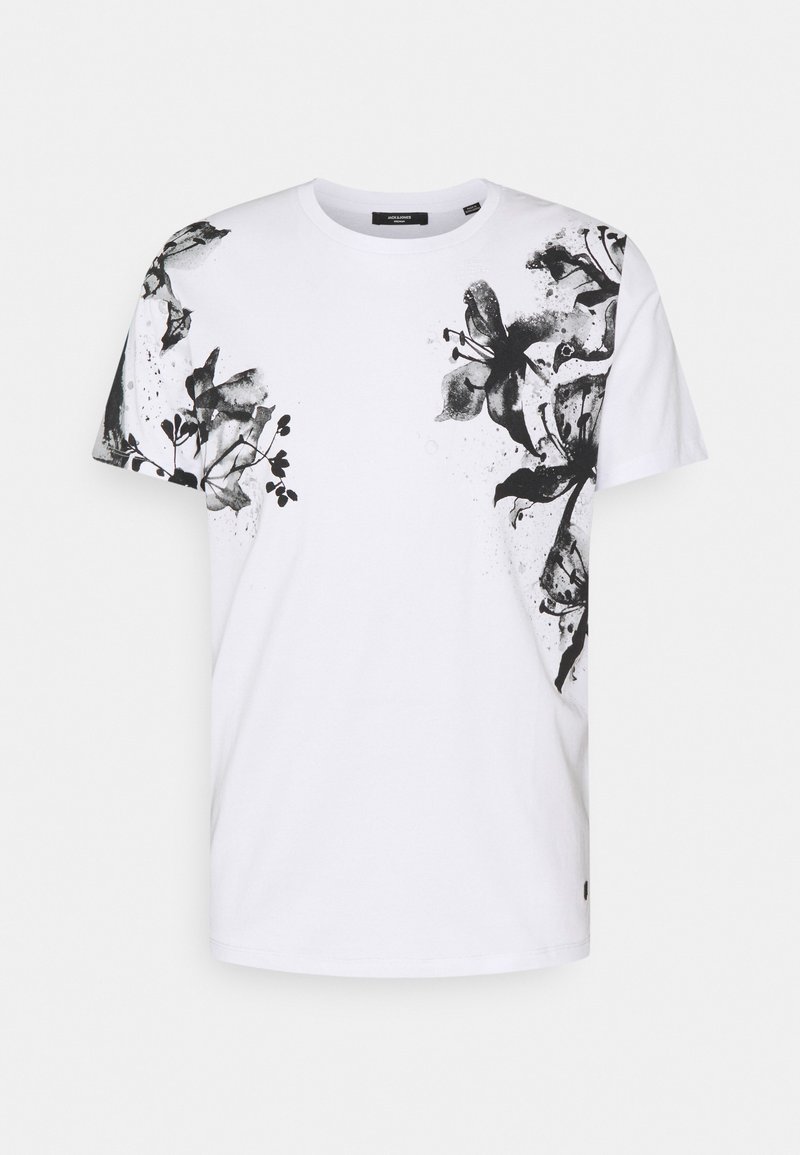 T-shirt de algodão branco com um design de impressão floral preta no lado esquerdo, com mangas curtas e decote redondo.