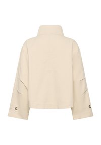 Kremno obarvan krajec jakne z visokim ovratnikom in širokimi rokavi. Ima zaponke na manšetah in gladko teksturirano tkanino. Brez vidnih vzorcev.