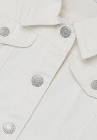 Camicia in tessuto di denim bianco con colletto strutturato, caratterizzata da bottoni a pressione argentati e schemi di cucitura visibili.