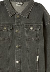 Šedá džínová bunda se dvěma kapsami na hrudi, kovovými knoflíky a sklopeným límcem. Tkanina má jemnou strukturu a není podšívkovaná.