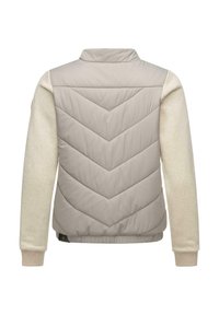 Jachetă puffer de un bej deschis, cu un design de tip chevron quiltat pe spate și mâneci de crem, asemănătoare cu un hanorac. Prezintă un logo mic pe lateral.