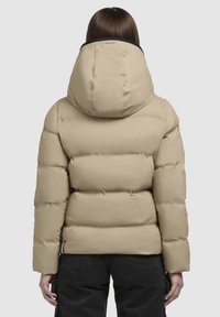 Beige Daunenjacke mit großer Kapuze, gestepptem Material und schwarzen Kragenakzenten. Verfügt über Reißverschlusstaschen an den Seiten.
