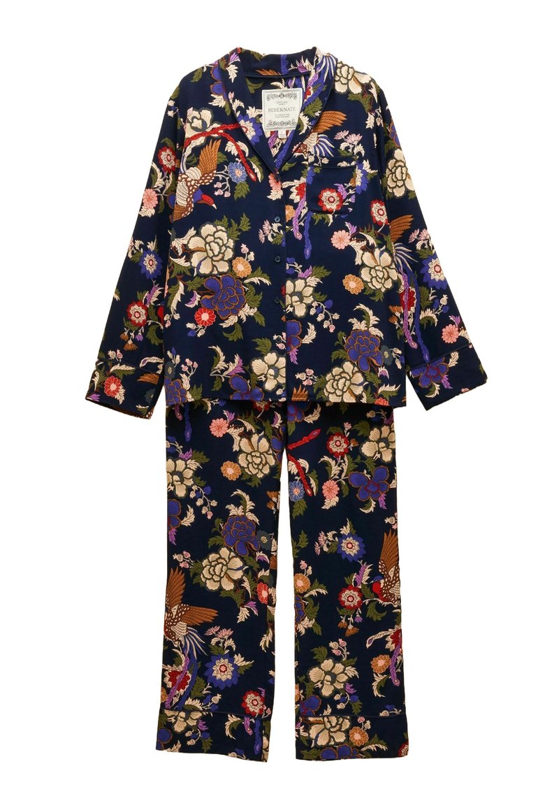 Pajama set s cvjetnim uzorkom od mekane tkanine. Tamnoplava podloga s šarenim cvjetovima i pticama, košulja s dugmadi i džepom, te hlače u kompletu.