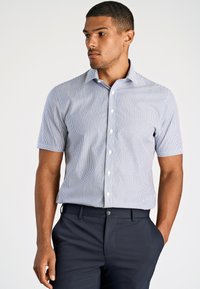 Camicia a maniche corte con bottoni di colore azzurro chiaro, decorata con righe verticali bianche. Presenta un colletto classico e una texture di cotone liscia.