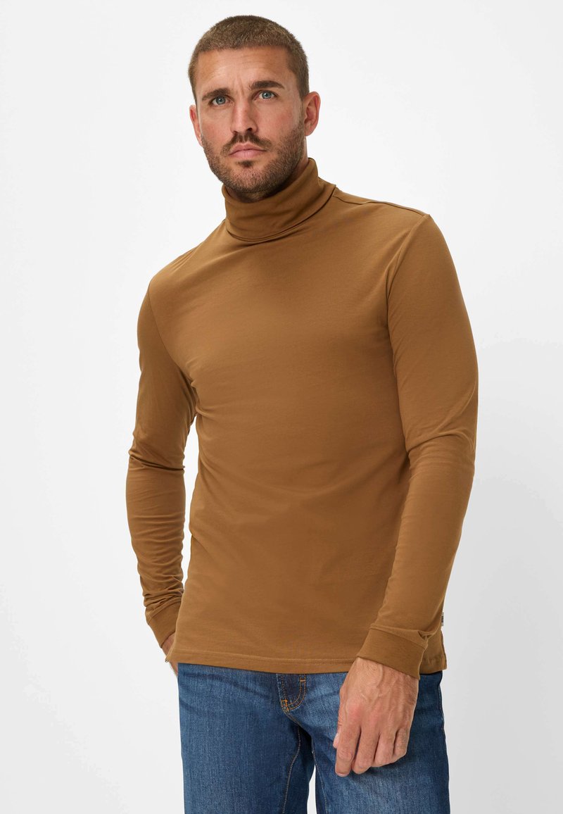 Maglione a collo alto marrone a maniche lunghe realizzato in tessuto morbido, dal design aderente, con una leggera elasticità, abbinato a jeans blu.